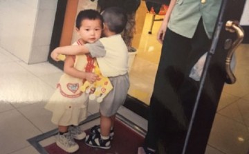 A little boy gives a female kid a hug outside a cake shop in Wanxincun in Hedong District, Tianjin, in Aug. 1999. The grown-up girl now wants to know his identity.