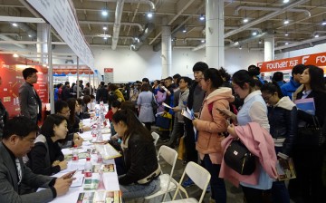 Job applicants consult recruitment information at a labor market on Feb. 27, 2016 in Dalian, Liaoning Province.