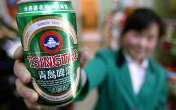 A can of Tsingtao beer is displayed by a clerk at a food market.