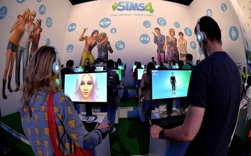Visitors try out the game 'SIMS 4' at the Electronic Arts stand at the 2014 Gamescom gaming trade fair on August 14, 2014 in Cologne, Germany. 