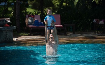 A man lifts a boy up in the air in a pool at the Club Med resort in Sanya, which was bought by Fosun in 2015.