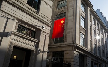 The Chinese national flag hanging in sunshine from the Bank of China's headquarters in the City of London, United Kingdom.