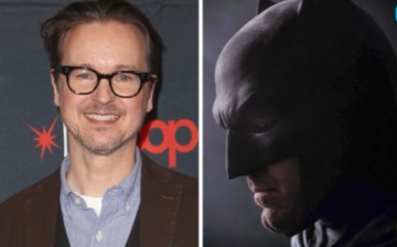 Director Matt Reeves smiles for the camera alongside a photo of Ben Affleck as Batman.