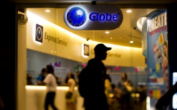 Shoppers try out mobile devices at a Globe Telecom Inc. retail outlet in Manila, Philippines.