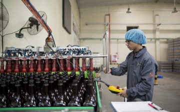 An employee seals bottles of Maggi seasoning on a machine at the Nestle Dongguan Ltd. factory in Dongguan, Guangdong Province.