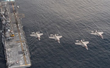 Four F-35B Lightning II aircraft perform a flyover above the amphibious assault ship USS America (LHA 6).                   