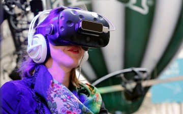 A visitor tries the virtual reality headset HTC Vive to experience 3D virtual reality during the show 