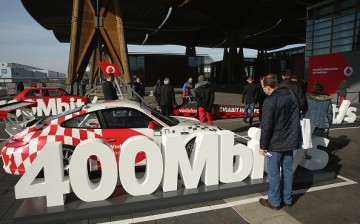 A visitor looks at a Porsche car meant to represent the speed of a 400 Mbit/s Internet connection at the 2016 CeBIT digital technology trade fair.