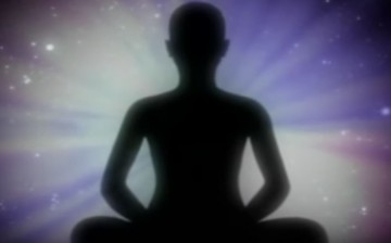 A shadow of man is displayed while he meditates. 