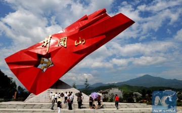 Tourists stand beside a monument to Communist partisans in Jinggangshan, Jiangxi Province, China.