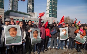 Residents hold posters of late communist leader Mao Zedong during a protest calling for a boycott of South Korean goods in Jilin, in China's northeast Jilin Province on March 5, 2017.