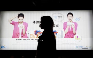A commuter walks past a China Mobile Ltd. advertisement in the Futian district of Shenzhen, China.