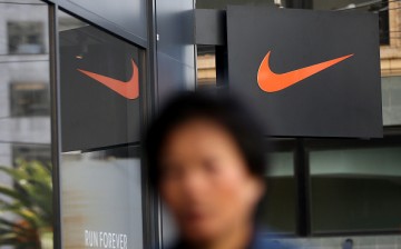 A pedestrian walks by a Nike store.