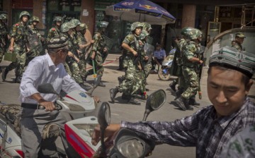 Chinese soldiers march past the Id Kah Mosque, China's largest, on July 31, 2014, in Kashgar, China.