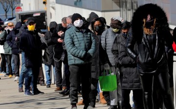 People wait in a line stretching around the Jacob K. Javits Convention Center on midtown Manhattan's west side, 