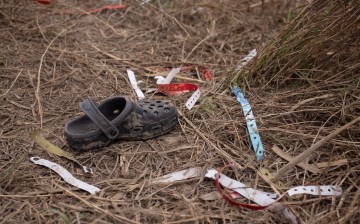 A shoe is seen surrounded by wristbands discarded by asylum seeking migrants from Central America along the banks of the Rio Grande river 