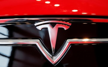 A Tesla logo on a Model S is photographed inside of a Tesla dealership in New York, U.S.,