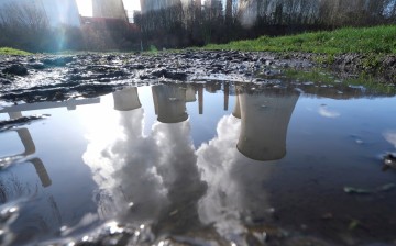 The lignite (brown coal) power plant complex of German energy supplier and utility RWE is reflected in a puddle in Neurath, north-west of Cologne, 