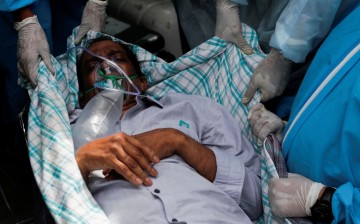 A patient suffering from the coronavirus disease (COVID-19) is evacuated from a hospital after it caught fire in Virar, on the outskirts of Mumbai, India,
