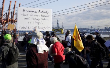 Shell Oil Company's drilling rig Polar Pioneer is seen in the background as activists march to the entrance of Terminal 5 to protest the rig which is parked at the Port of Seattle, Washington