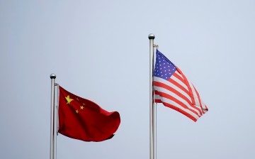 Chinese and U.S. flags flutter outside a company building in Shanghai, China