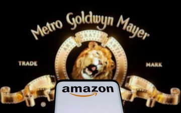 Smartphone with Amazon logo is seen in front of displayed MGM logo in this illustration