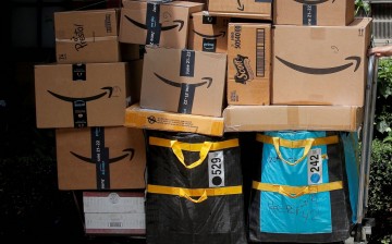 An Amazon delivery worker pulls a delivery cart full of packages during its annual Prime Day promotion in New York City, U.S