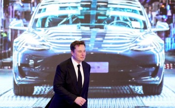 Tesla Inc CEO Elon Musk walks next to a screen showing an image of Tesla Model 3 car during an opening ceremony for Tesla China-made Model Y program in Shanghai, China