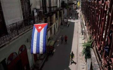 A Cuban flag hangs over a street in downtown Havana, Cuba