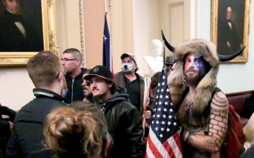 Jacob Anthony Chansley of Arizona stands with other supporters of U.S. President Donald Trump as they demonstrate on the second floor of the U.S. Capitol near the entrance to the Senate