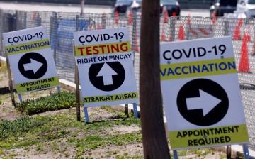 Signs guide the public at a large vaccination and testing site as people with preexisting health conditions are granted access to a vaccination during the outbreak of the coronavirus disease (COVID-19) in Inglewood,