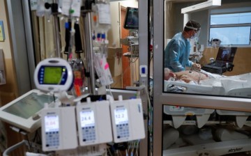 A critical care respiratory therapist works with a coronavirus disease (COVID-19) positive patient in the intensive care unit (ICU) at Sarasota Memorial Hospital in Sarasota,