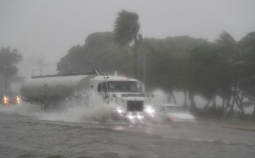Vehicles move through a flooded street during the passage of Tropical Storm Fred in Santo Domingo, Dominican Republic