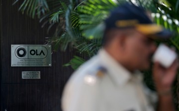  A policeman drinks tea in front of Ola's office in Mumbai, India