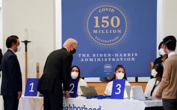 U.S. President Joe Biden speaks with medical workers during a visit to a coronavirus disease (COVID-19) vaccination site at Virginia Theological Seminary in Alexandria, Virginia, U.S.