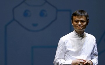 Jack Ma, founder and executive chairman of China's Alibaba Group, speaks in front of a picture of SoftBank's human-like robot named 'pepper' during a news conference in Chiba, Japan,