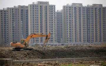 An excavator is seen at a construction site of new residential buildings in Shanghai, China