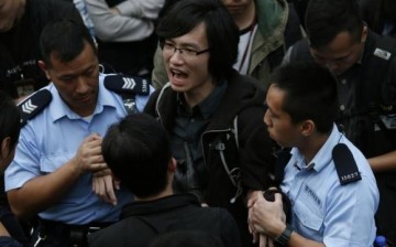 A pro-democracy protester chants slogans as he is taken away by the police.