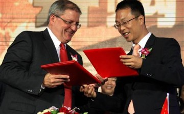 Gerry Lopez (R), chief executive of AMC Entertainment, sits next to Wang Jianlin, president of Wanda Group.