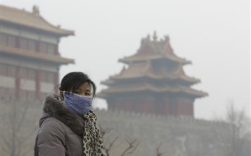 A Chinese woman wears a mask outside the Forbidden City due to heavy haze.