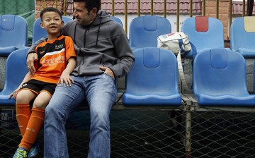 Luis Figo talks to a young Chinese boy who attended a football clinic conducted by the Figo Football Academy.