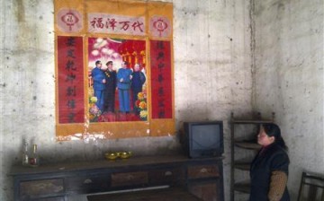 A Chinese villager looks up at a political poster.