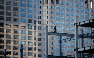 A worker walks down a beam at a construction site in Beijing.