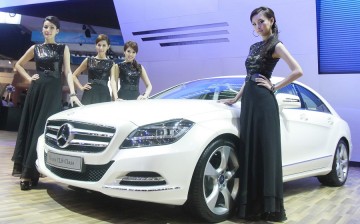 Models pose beside a new Mercedes-Benz CLS during the 32nd Bangkok International Motor Show in Bangkok, March 24, 2011. 