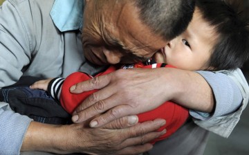 Wang Bangyin, a local farmer, holds his rescued son after the pair were reunited at Guiyang Welfare Centre for Children in Guiyang, Guizhou Province, Oct. 29, 2009. 