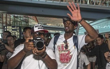 NBA player Dwyane Wade (front R) waves to fans in China.