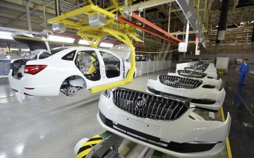 An employee looks on next to an assembly production line of Buick cars at a General Motors factory in Wuhan, Hubei Province, Jan. 28, 2015.