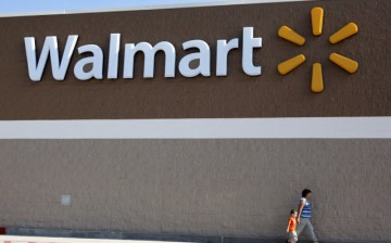 People are walking past a Walmart sign outside a store in Arkansas.