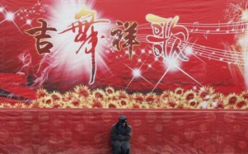 A guard sits in front of a Chinese New Year celebration stage in China.