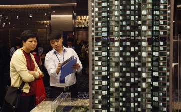A potential buyer listens to a property sales agent at a promotional event in Hong Kong, Sept. 5, 2013. 
